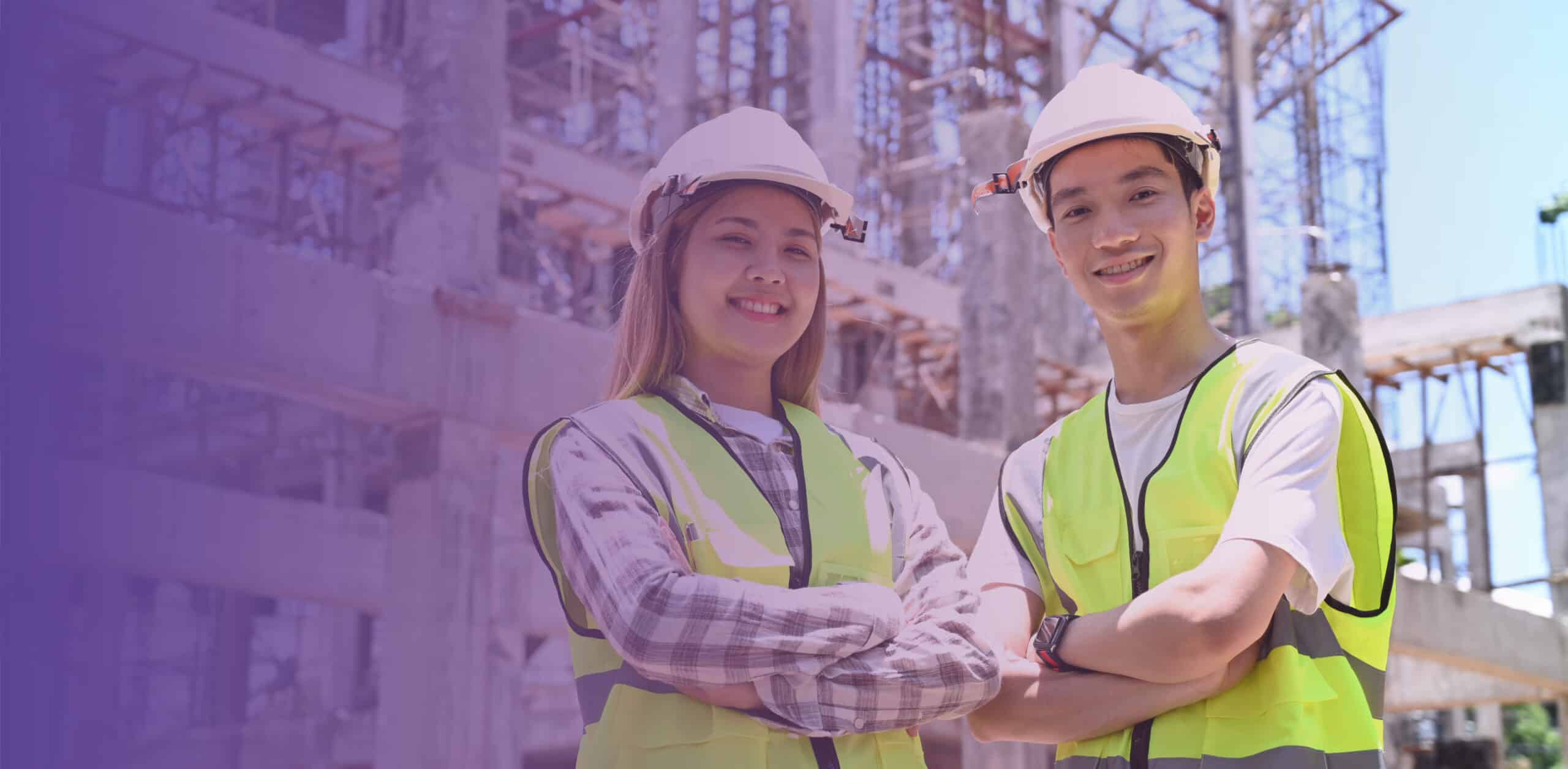 Two young people stood in front of a Construction site