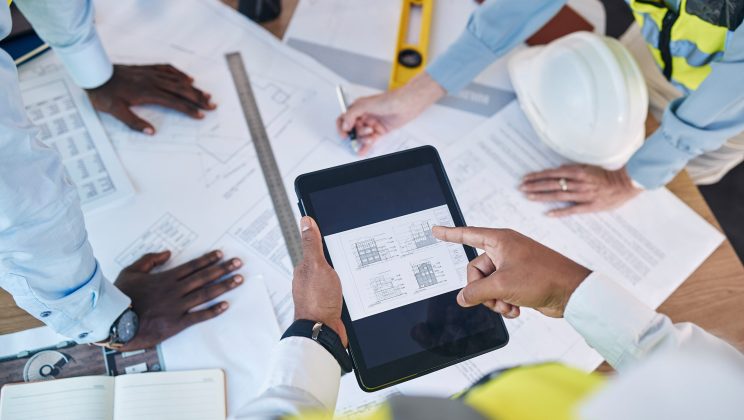 Architect, hands and tablet in construction above for team planning, strategy or floor plan for pro.