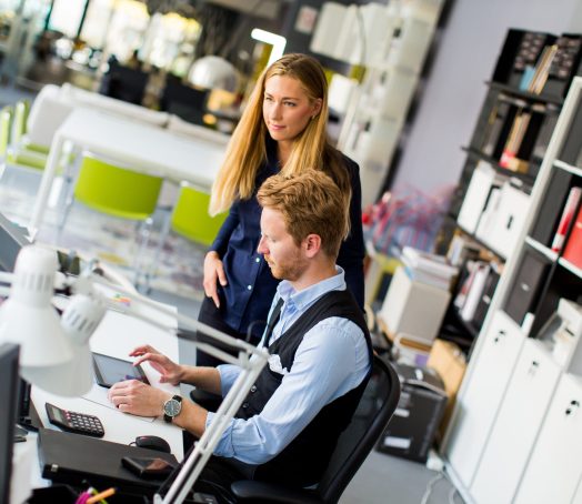 View at young business couple using laptop in the office
